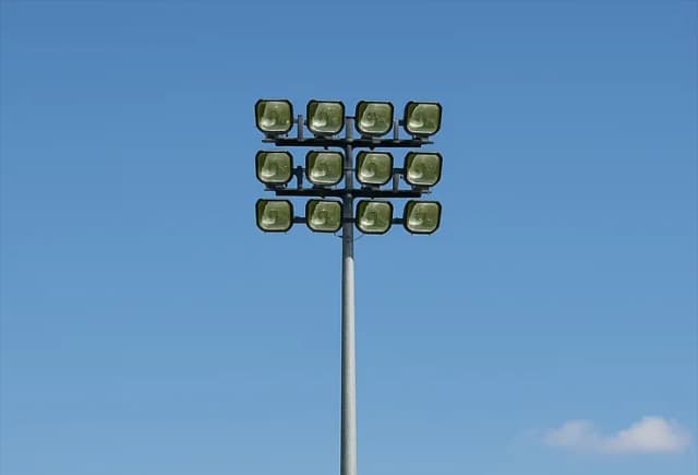 Tall sports lighting pole anchored with steel foundation footing
